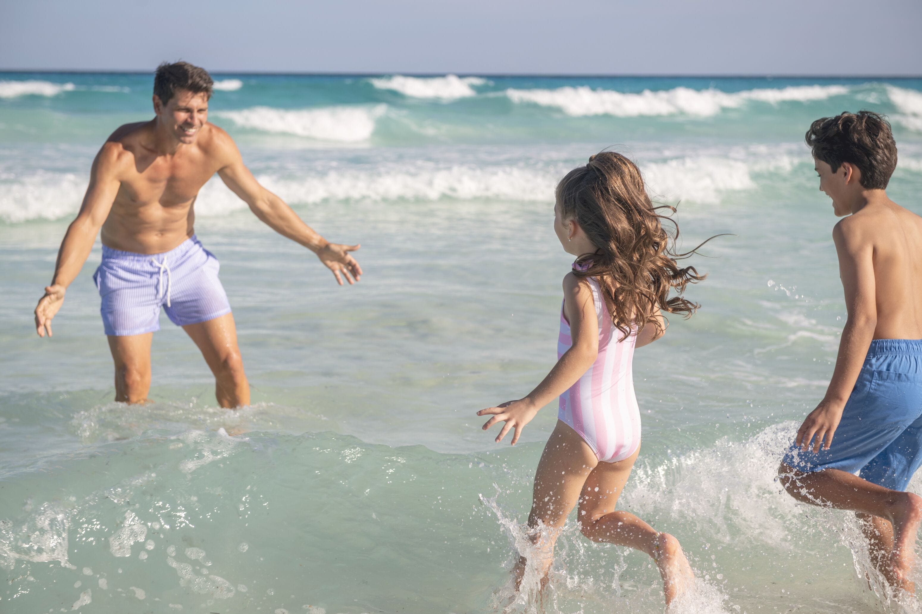 A beach scene with clear water and waves.