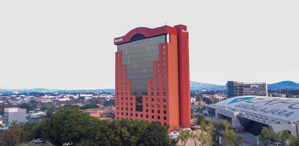 A tall red building with a large glass facade and a sign reading "Barceló."