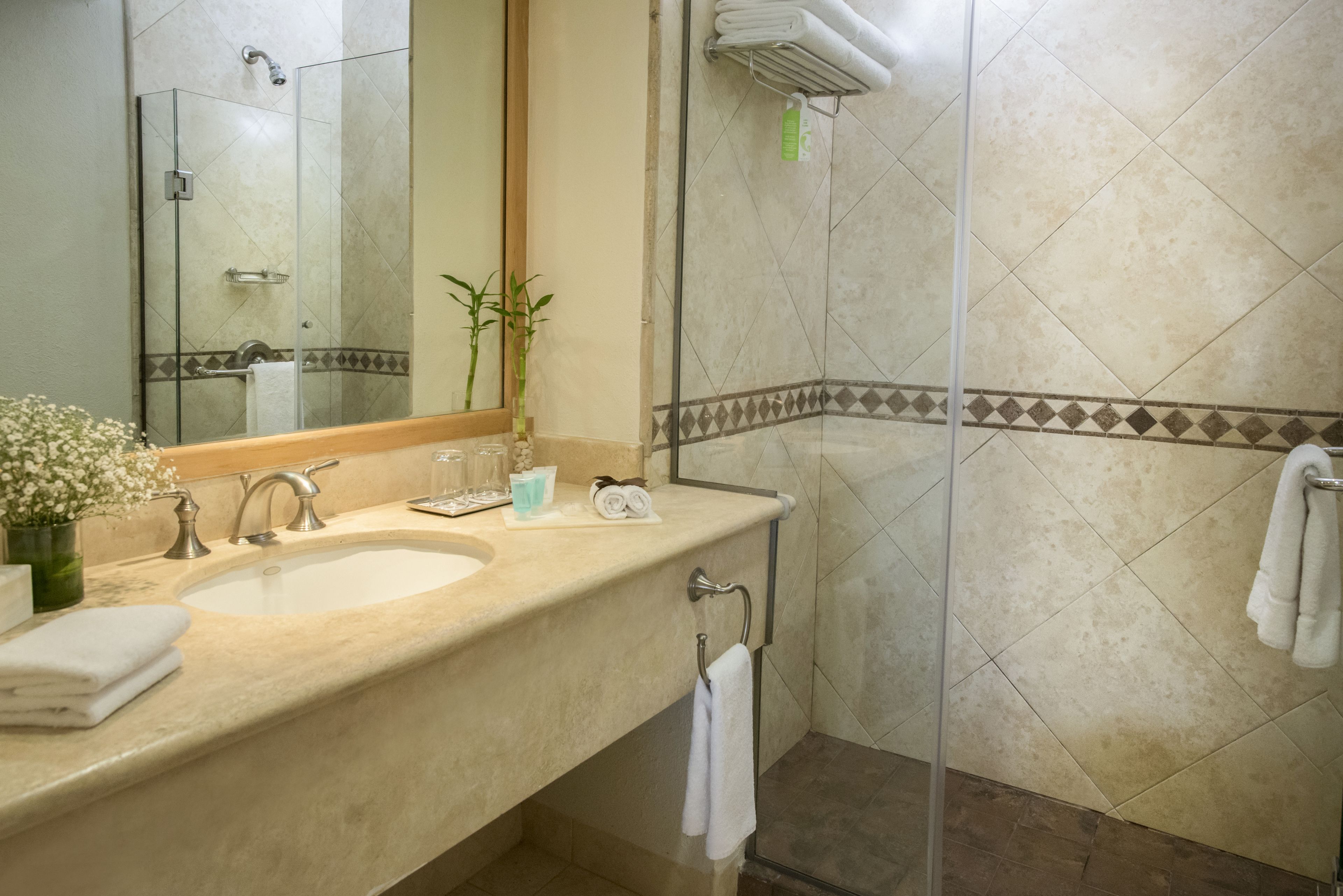 Un baño con lavamanos, espejo y ducha.