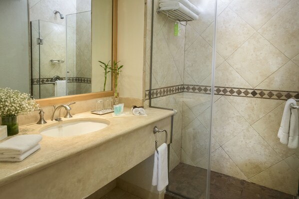 A bathroom with a sink, mirror, and shower.
