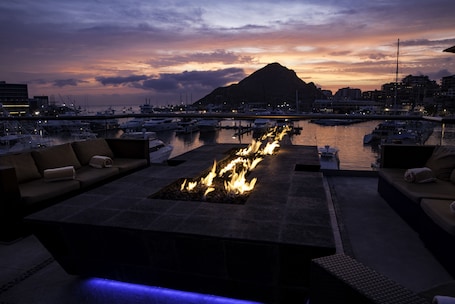 Terraza en la azotea con chimenea, asientos y vista al puerto deportivo.