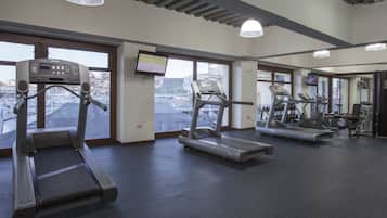 A gym with treadmills, a stationary bike, and a weight bench.