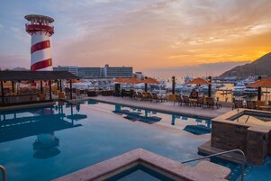 Una piscina al aire libre, camas de piscina con cargo, sombrillas