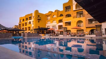 Un hôtel doté d’une piscine, d’un espace extérieur aménagé et de bâtiments aux façades jaunes.