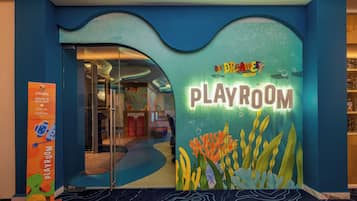 Un salón de juegos con temática acuática en azul y verde, que muestra un cartel que dice "The Dreamy Playroom".