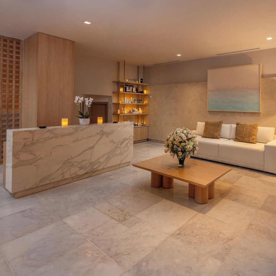 A modern living room with a marble reception desk, a sofa, a coffee table, and a floor lamp.