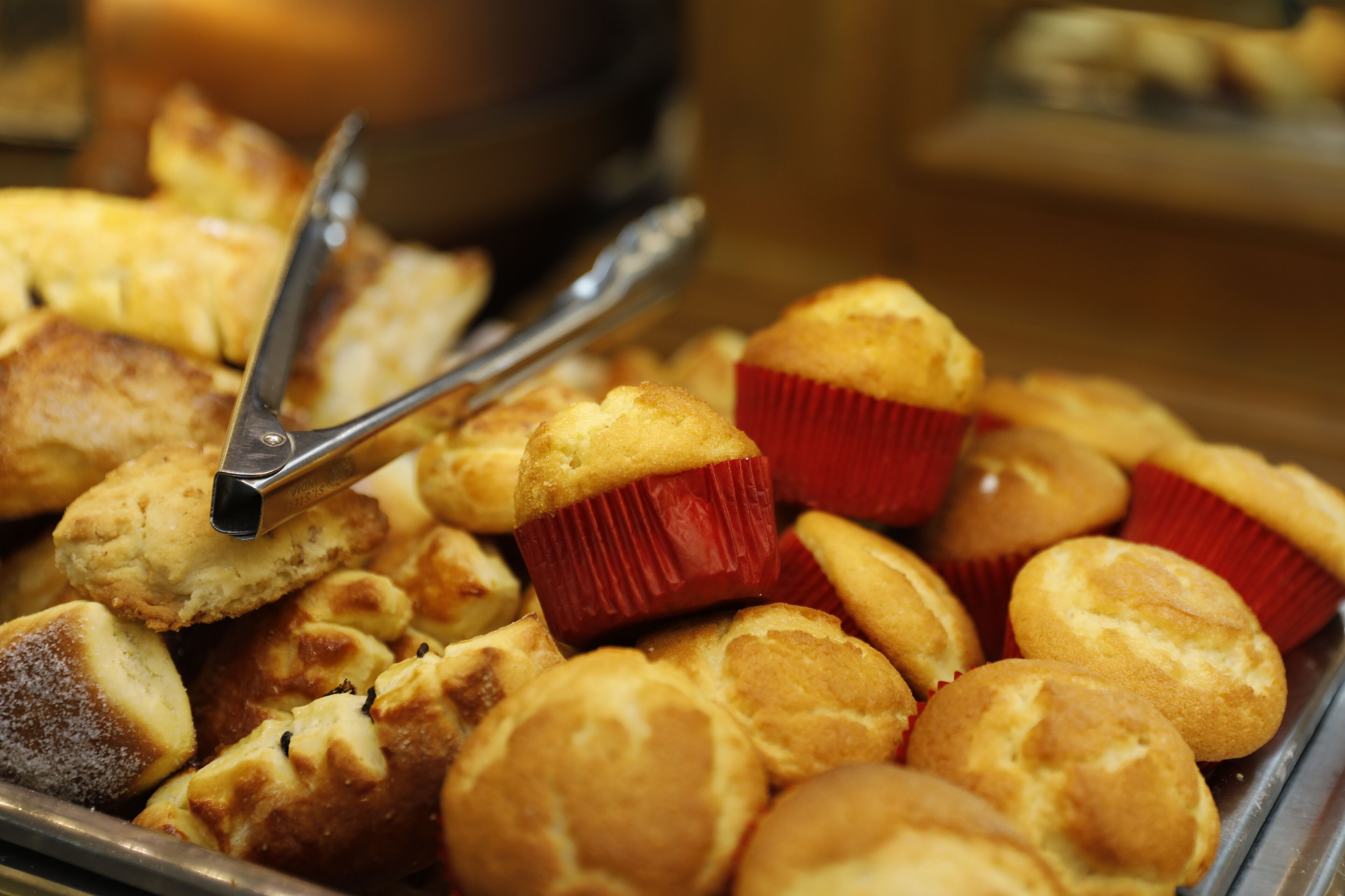Un plateau contenant un assortiment de produits de boulangerie, notamment des muffins et des viennoiseries.