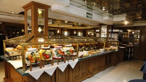 A buffet area with various food items and a wooden counter. - Country Plaza (Zapopan)