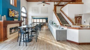 A spacious kitchen with a central island, wooden beams, and a staircase. - Chase Suites Hotel Brea-Fullerton (Brea)