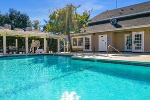 Una piscina al aire libre, sombrillas