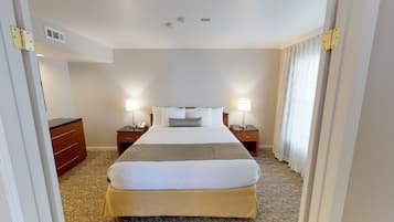 A hotel room with a large bed, two bedside tables with lamps, a telephone, and a wardrobe.