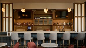 A bar area with a counter, bar stools, and a seating area with round tables and chairs. - DoubleTree by Hilton Fullerton (Fullerton)