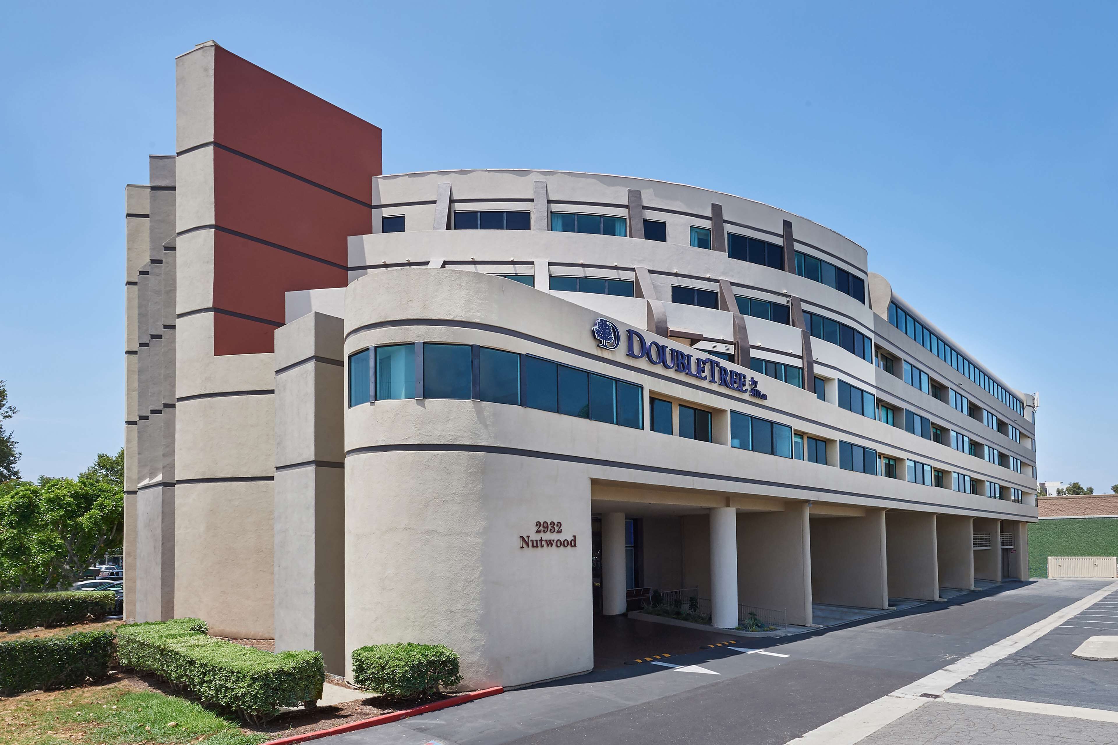 A modern building with a curved facade, the name "Doubleday" visible, and the address "2932 Nutwood."