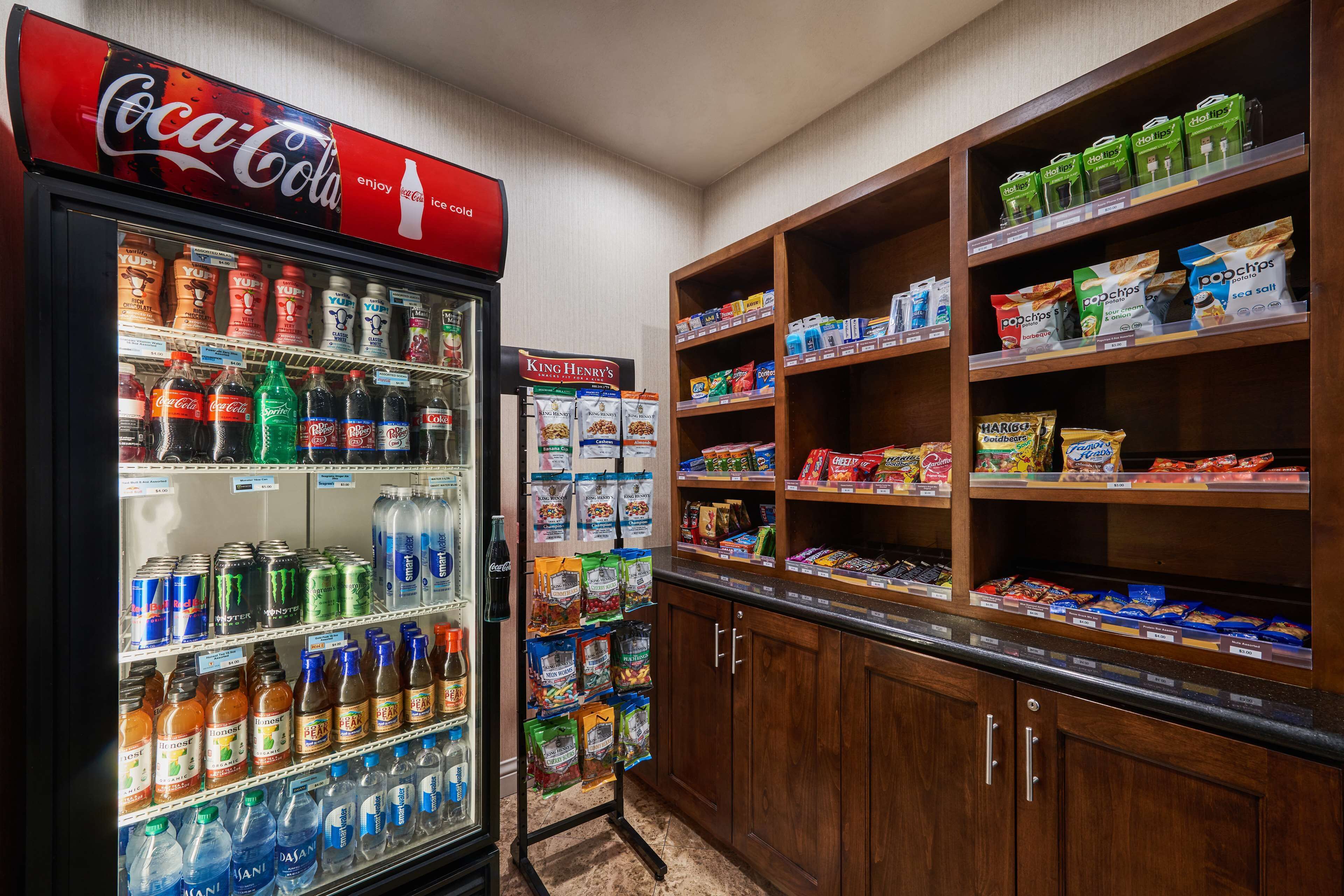 A vending machine with various drinks and snacks, including Coca-Cola and Yoplait yogurt cups.
