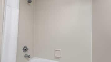Un baño con bañera, cabezal de ducha y perchero.