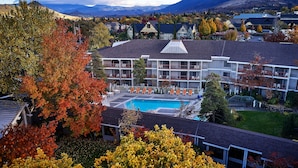 Un hotel con piscina, varios balcones y vistas del paisaje circundante.