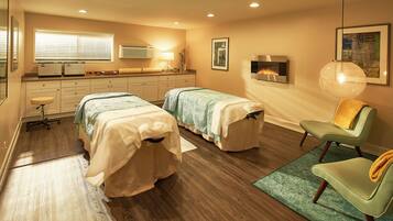 Relax in this stylish room with two single beds, a comfortable armchair, and a wall-mounted fireplace.