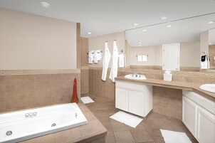 Un baño moderno con bañera, un espejo grande y un tocador con lavabo.