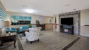 Amplia sala de estar con chimenea, televisión y asientos cómodos.