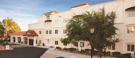 Un hôtel doté d’un parking, de places de stationnement réservées aux personnes handicapées et d’un panneau indiquant « Homewood Suites ».