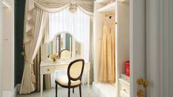 Una habitación con tocador, silla, espejo, cómoda y armario.