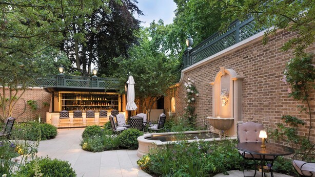 Un bâtiment en briques doté d’un bar, d’une terrasse et d’une fontaine.