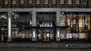 Un bâtiment moderne doté d’une grande vitrine sur laquelle on peut lire le mot « VOGUE ».