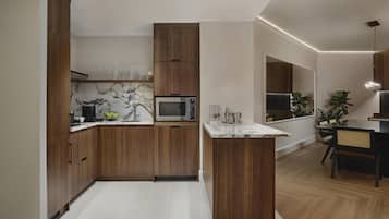 Une cuisine moderne avec des meubles en bois, un pare-feu en marbre et un four à micro-ondes encastré.