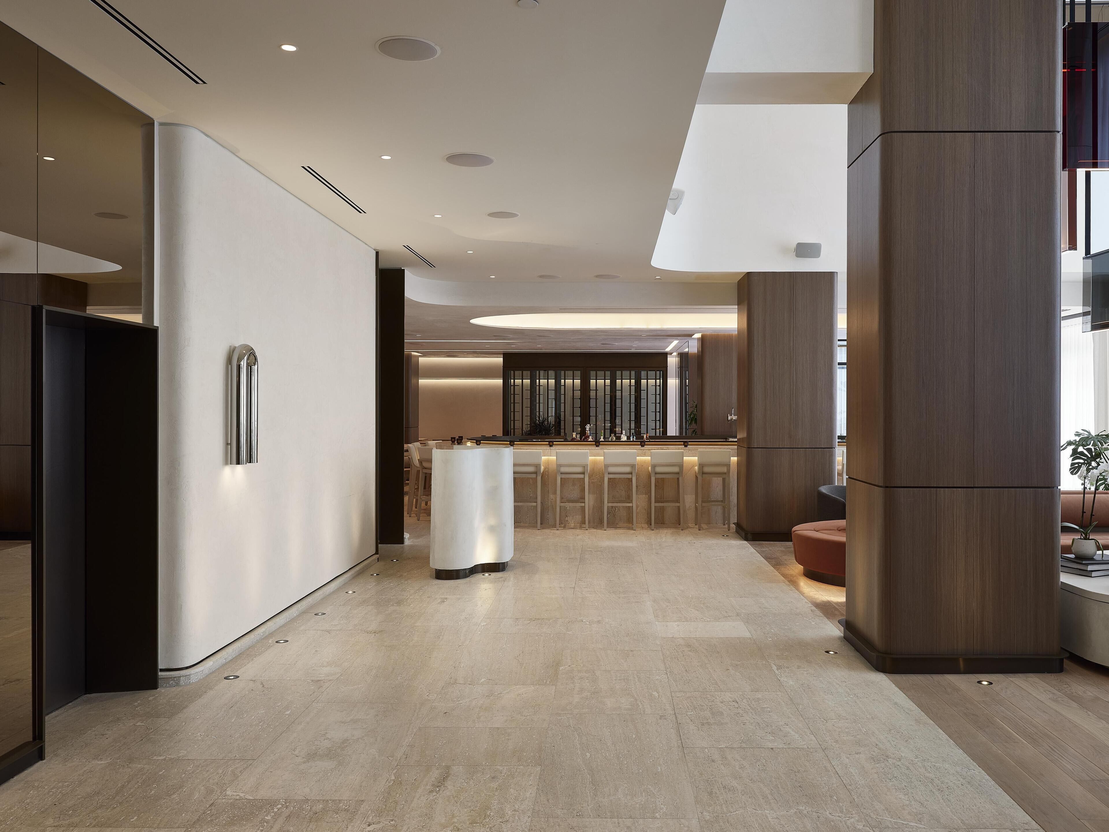 A modern kitchen with a central island, a bar area, and a seating space.