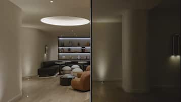 Ein modernes Wohnzimmer mit einer gebogenen Couch, einem runden Couchtisch und einer eingebauten Regaleinheit mit Dekorationselementen.