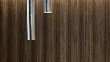 Een moderne receptiebalie met een metalen kraan en een gestructureerde wand.