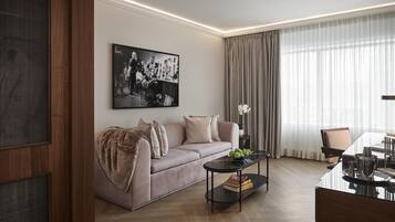 A modern living room with a sofa, a coffee table, and a dining area.
