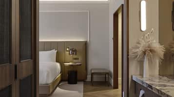 Een moderne hotelkamer met een houten vloer, een bed met witte lakens, een nachtkastje met een lamp en een klein bankje.