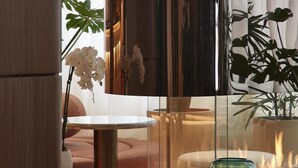 Un intérieur moderne avec une cloison en verre, une cheminée et des livres sur une table.