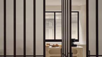 A modern interior with a sliding door leading to a bathroom with a marble countertop and a bathtub.