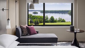 A modern hotel room with a large window offering a view of a lake and greenery. - Ann Arbor Marriott Ypsilanti at Eagle Crest (Ypsilanti)