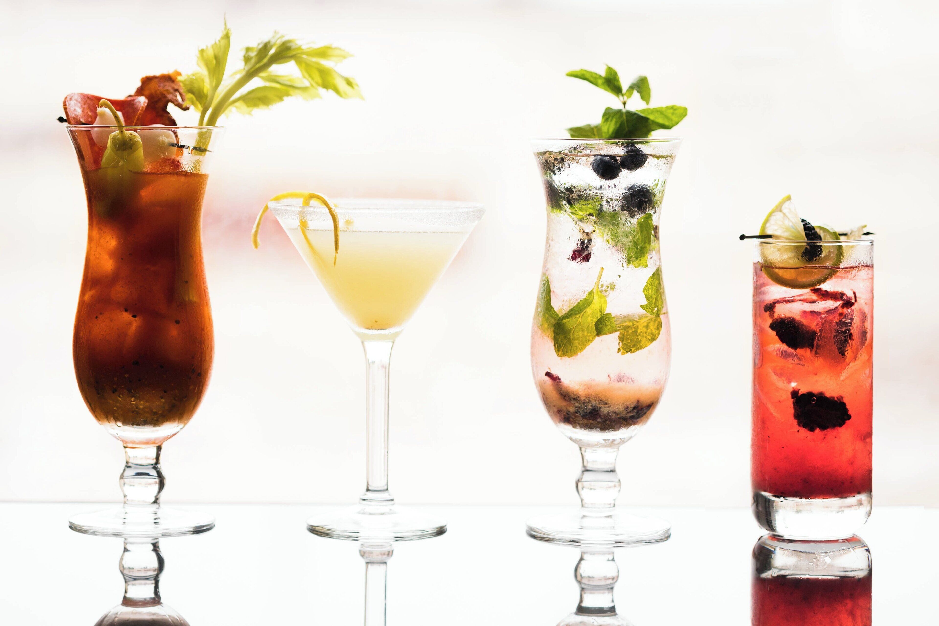 Four different cocktails in various glasses.