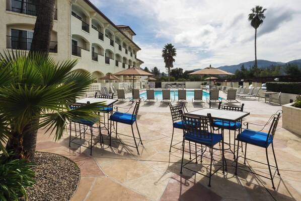 Alberca al aire libre, sombrillas en la alberca y camastros 