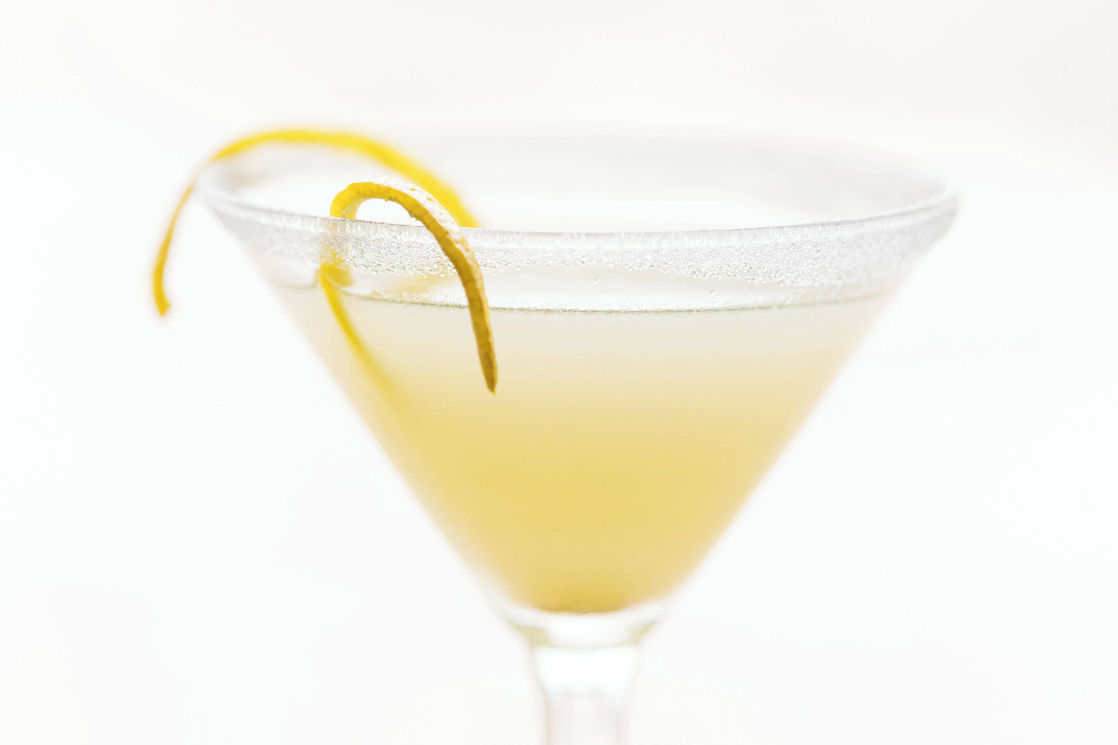 Una copa de martini con un adorno de gajo de limón.