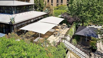 Ein modernes Gebäude mit einer großzügigen Terrassenfläche, Außenmöbeln und einer Treppe, die zu einer oberen Ebene führt.
