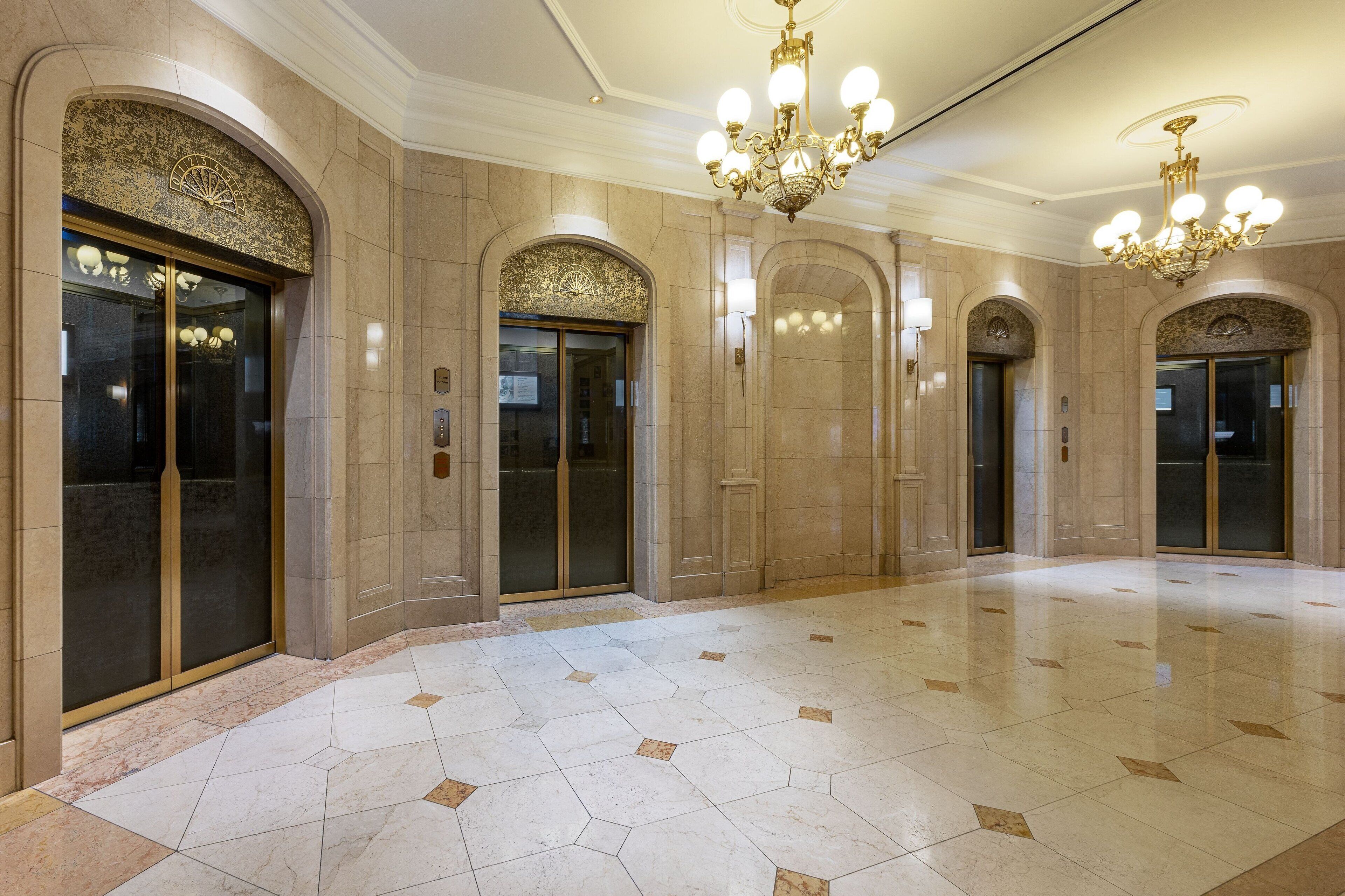 Eine großzügige Lobby mit Marmorböden, hohen Rundbogenöffnungen und aufwendigen Kronleuchtern.