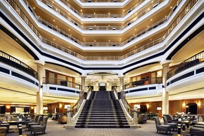 A multi-level hotel lobby with a grand staircase, multiple floors, and seating areas. - The Westin Grand Berlin (Berlin)