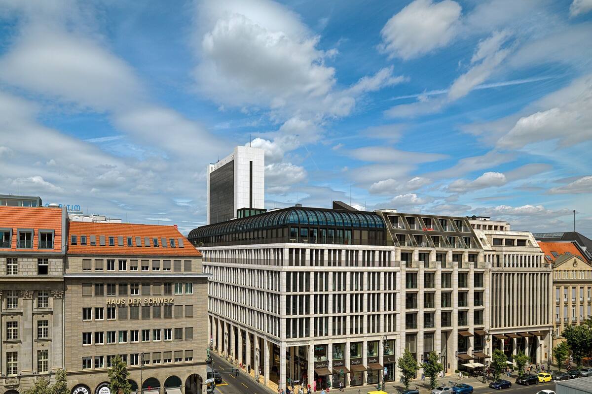 A multi-story building with a modern architectural design, featuring a prominent curved glass facade and a flat roof.