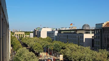 Paisatge urbà amb edificis moderns, una cúpula destacada i un carrer arbrat.