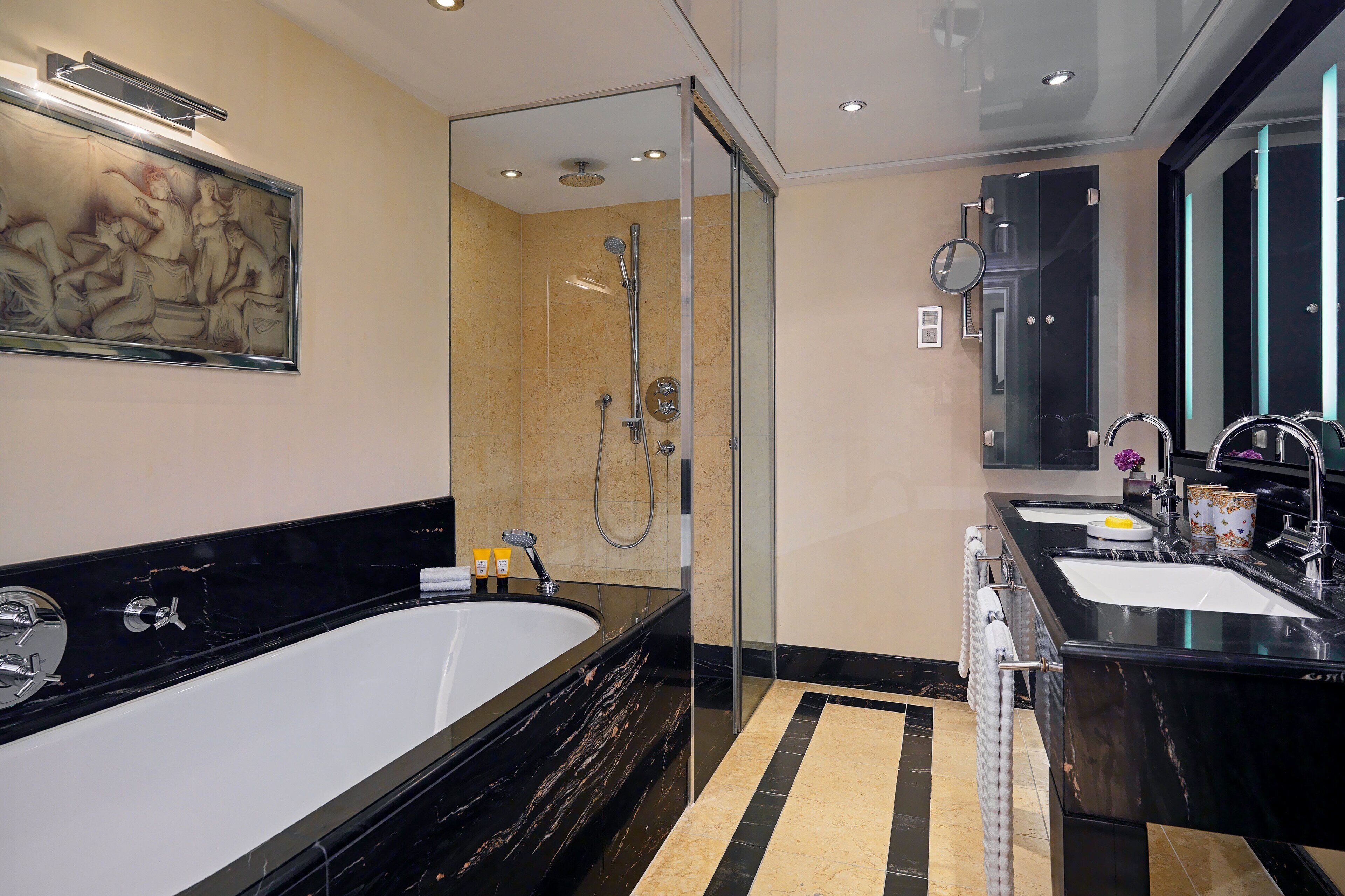 A modern bathroom with a large bathtub, a separate shower area, and a vanity with two sinks.