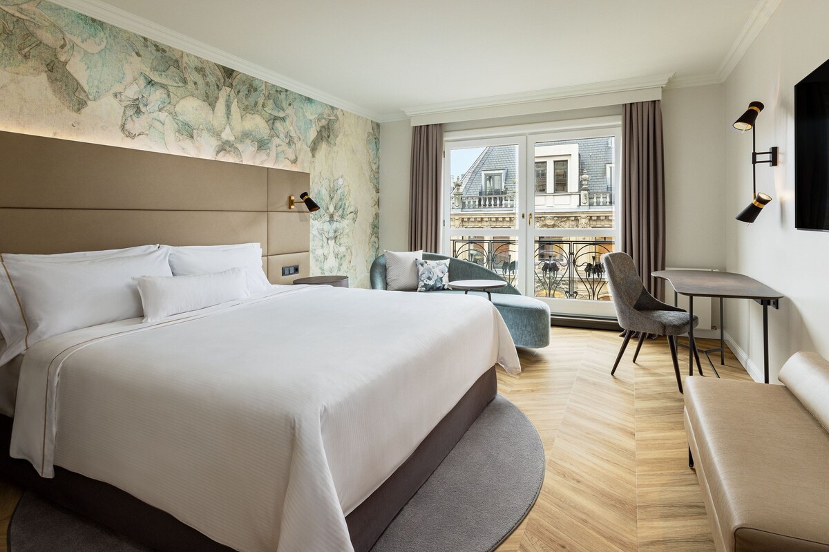 Modern hotel room with black and white decor.
