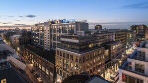 Un edificio moderno con un llamativo letrero 'MARITIM', que cuenta con fachada de vidrio y varios pisos.