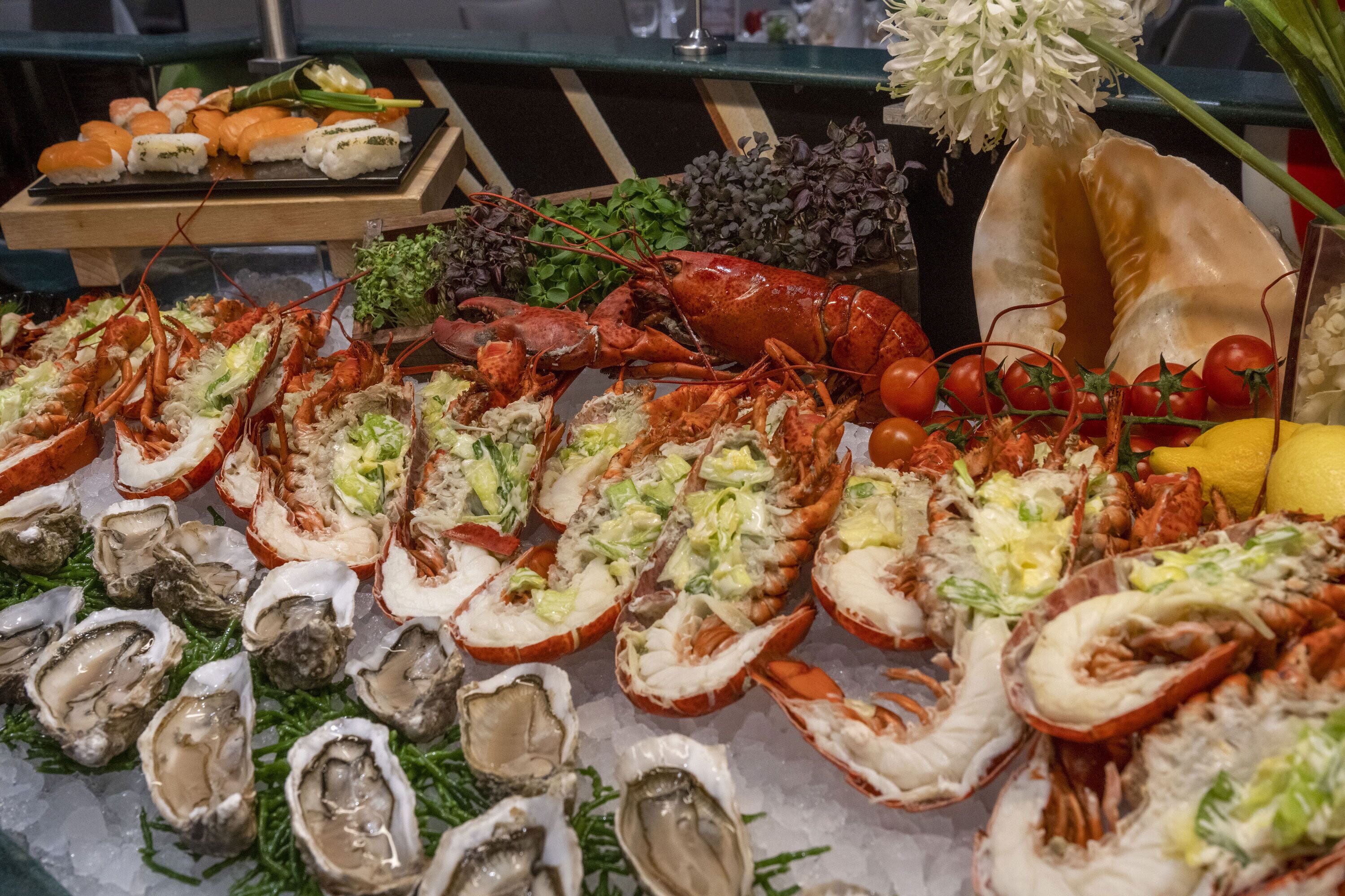 Una exhibición de mariscos con langostas, ostras y tomates.