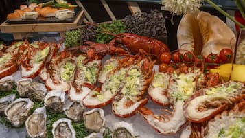 Una exhibición de mariscos con langostas, ostras y tomates.
