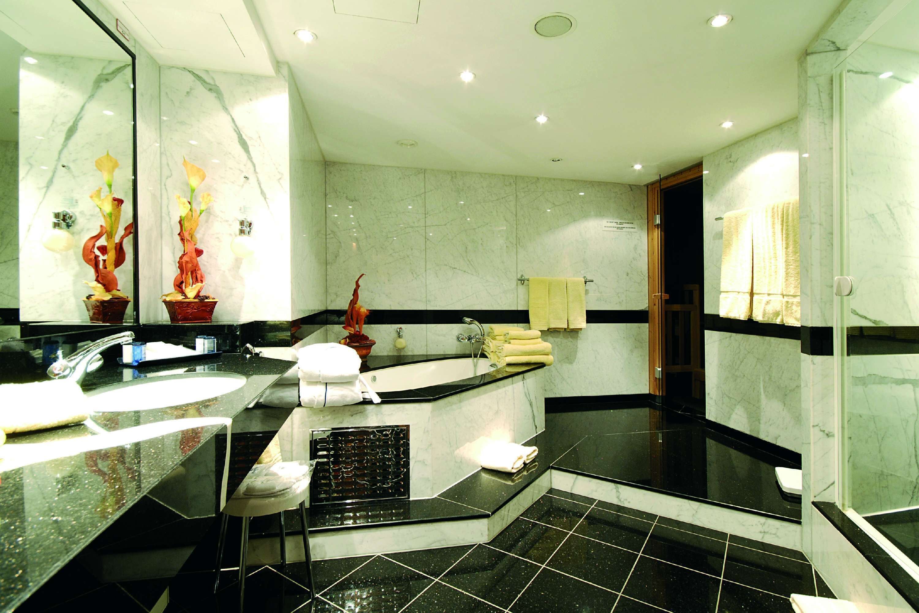 Ein modernes Badezimmer mit großem Spiegel, einer Badewanne und einer Duschkabine.
